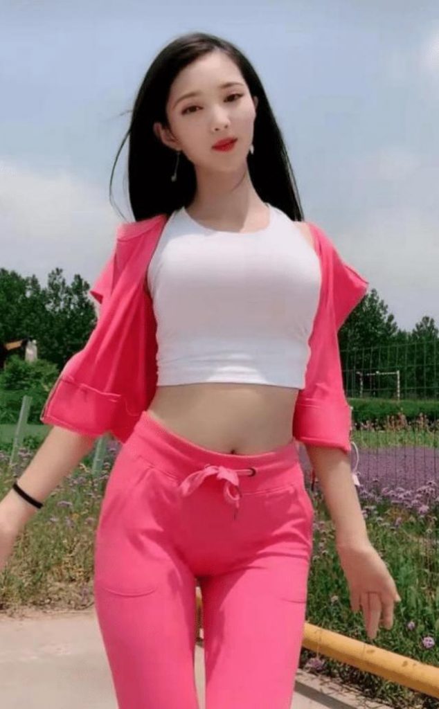 辣妈一身玫红色运动装真显身材，后面的野花不摘几朵回家吗？