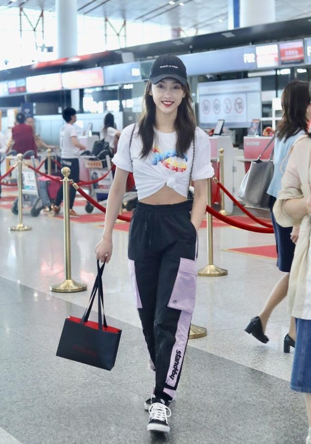 张含韵真会玩，把T恤下摆中间剪开，系个蝴蝶结，效果意外好看